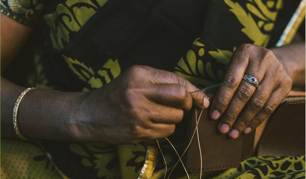 Hands sewing leather goods